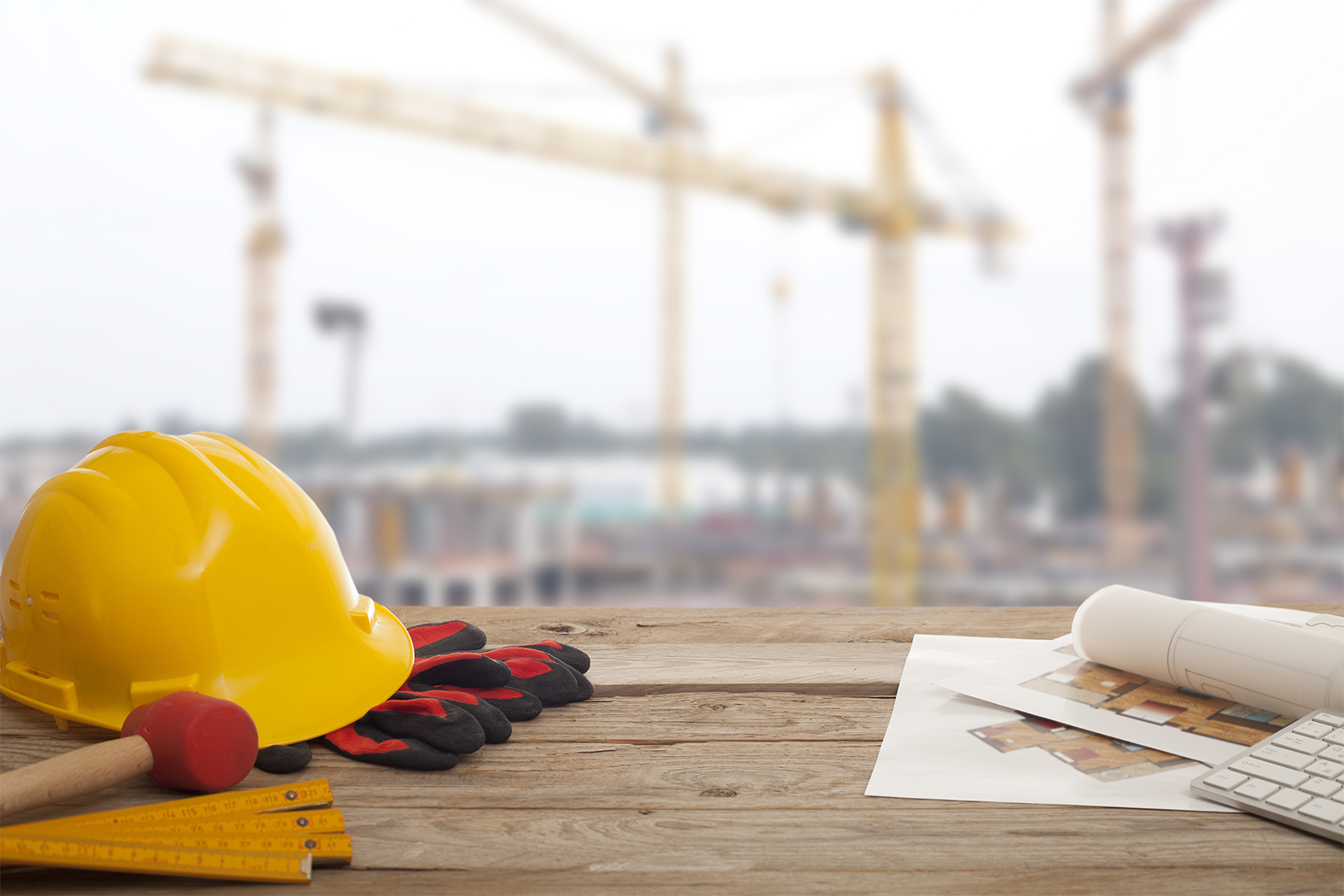 Casque, plans et outils de construction devant un chantier